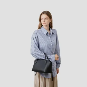 Sac à main classique en cuir noir associé à une chemise rayée pour un look chic au quotidien.