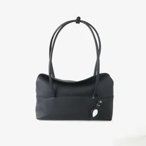 Sac épaule noir élégant en cuir souple texturé avec de longues anses fines et design raffiné.