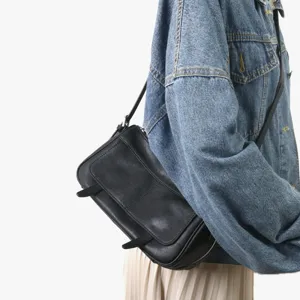 Sac bandoulière en cuir noir avec rabat, style vintage minimaliste chic pour femmes.