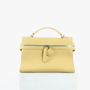 Vue détaillée du sac à main jaune en cuir, mettant en valeur la texture et la fermeture.