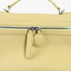 Vue détaillée du sac à main en cuir véritable jaune avec fermeture éclair et métal de luxe.