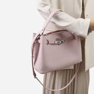 Vue détaillée du sac à épaule en cuir rose avec fermoir tourniquet et poignée supérieure.