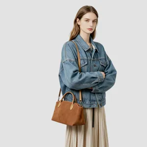 Vue rapprochée du sac à main en daim marron montrant la texture détaillée et la poignée.