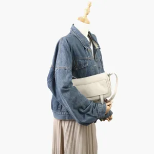 Détail du sac à épaule minimaliste en cuir vintage présenté avec une tenue en denim.