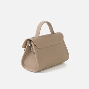 Vue détaillée du sac à main en cuir taupe montrant une texture grenue et des accessoires.