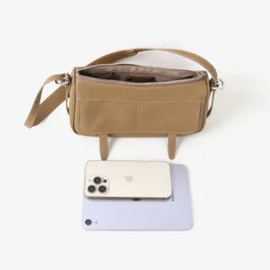 Détail de sac à épaule en cuir montrant le design des poches avant et taille compacte.