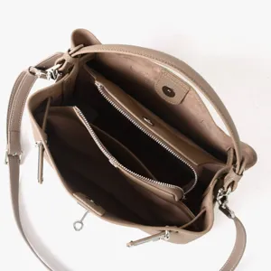Vue détaillée des compartiments intérieurs et des ferrures métalliques de ce sac en cuir.