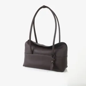 Vue détaillée du sac porté épaule sous les bras en cuir marron foncé, texture souple.