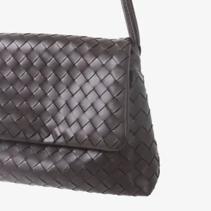 Détail de sac à main en cuir tissé marron foncé, gros plan élégant sur le rabat intrecciato