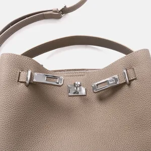 Gros plan détail du sac à main pour femme en cuir véritable avec serrure métal et texture.