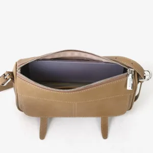 Vue détaillée de l'intérieur du sac à bandoulière en cuir marron et des ferrures métalliques.