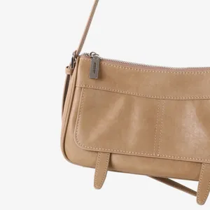Gros plan du sac en cuir rétro montrant des coutures fines et une fermeture éclair.