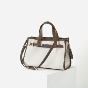Sac cabas en toile et cuir vue de détail, sac à épaule élégant avec fermoir métallique et brides.