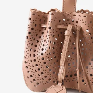 Vue détaillée d'un sac seau chic en cuir doté de motifs géométriques ajourés au laser.