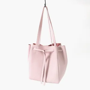 Détail de sac cabas cordon en cuir rose montrant une texture fine, structure douce et nœud élégant.
