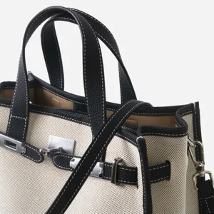 Élégant sac cabas en toile et cuir avec poignée et serrure métallique pour femme.