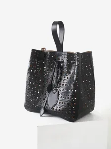 Sac seau noir en cuir avec découpe laser géométrique et poignée supérieure élégante.
