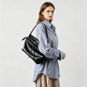 Vue detaillee d'un sac porte-epaule noir en cuir de grande capacite porte par un mannequin.