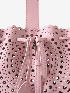 Sac seau en cuir rose avec motif ajouré découpé au laser, bord festonné et cordon.