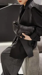 Détail de sac croissant en cuir noir, sac bandoulière souple en mouton, style minimaliste.
