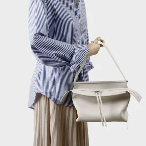 Detail sac porte epaule en cuir blanc creme, design elegant avec fermeture eclair.