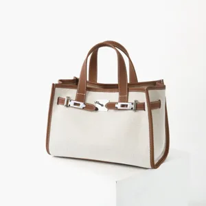 Vue détaillée du sac cabas en toile et cuir véritable avec coutures fines et serrure métal.