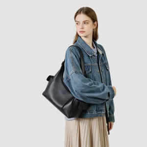 Vista detallada del bolso bandolera de cuero negro llevado por modelo, elegante.
