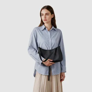 Sac porté épaule hobo en cuir noir en détail, design minimaliste élégant de ville.