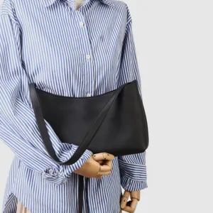 Vue détaillée d'un sac porté épaule noir en cuir véritable avec un design croissant élégant.
