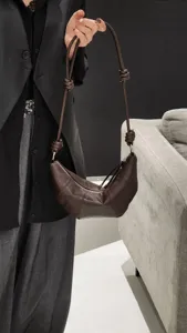 Sac bandoulière croissant en cuir marron détail, design incurvé élégant avec une lanière.