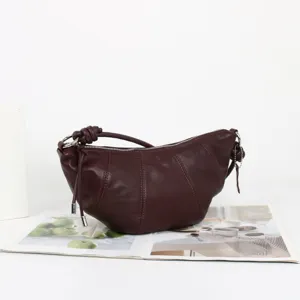Vue détaillée du sac porté épaule croissant en cuir souple de couleur bordeaux.