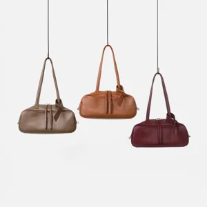 Vista detallada de elegantes bolsos tipo bolo de cuero colgantes, textura premium y diseño elegante.