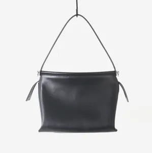 Détail de sac porté épaule minimaliste en cuir noir, parfait pour le travail et les loisirs.