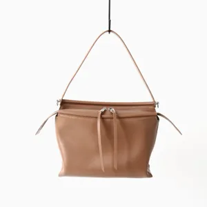 Vue détaillée du sac porté épaule en cuir marron, soulignant la fermeture éclair et la lanière.