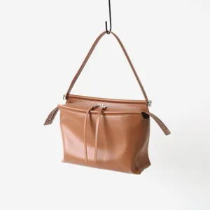 Gros plan sur les détails du sac porté épaule marron élégant avec fermeture éclair.