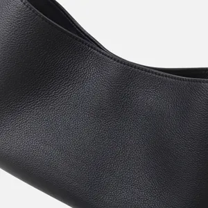 Gros plan détail du sac porté épaule hobo en cuir noir avec de très fines coutures.