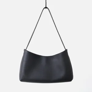Détail de sac porté épaule hobo en cuir noir, design croissant minimaliste et élégant.