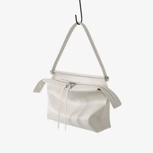 Détail du sac à épaule minimaliste uni avec fermeture éclair et curseurs longs de qualité.