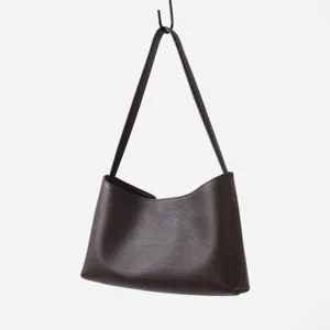 Sac porté épaule hobo en cuir marron foncé, détail de sac sous les aisselles en cuir.