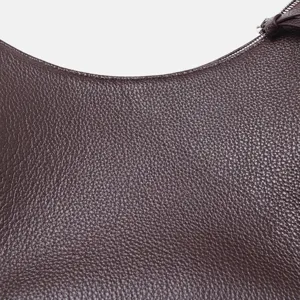 Primer plano detallado de bolso de hombro de cuero genuino marrón oscuro, grano lichi.