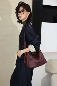 Vue détaillée d'un sac porté épaule en cuir tressé, élégant cabas marron foncé pour femme.