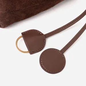 Détail de cordon en cuir suédé marron, texture premium, accessoire élégant pour sac.