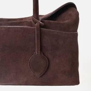 Sac cabas en daim marron détail gros plan, design minimaliste de luxe, sac à main de qualité.
