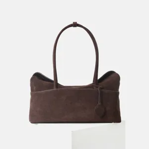 Vue détaillée du sac porté épaule en daim marron foncé, texture douce et anse élégante.