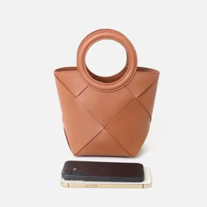 Brown woven leather handbag detail with round handle and phone scale reference on white background.
