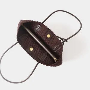 Gros plan détaillé de l'intérieur du sac cabas en cuir tressé marron foncé de qualité.