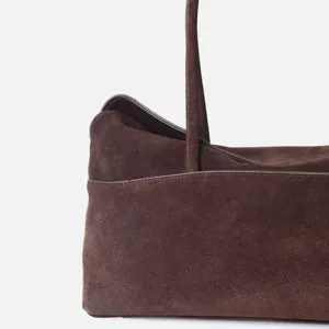 Gros plan sur le sac épaule en cuir velours marron montrant texture et belles coutures.