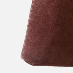 Gros plan sur le detail de sac en cuir suede marron, texture douce et coutures.