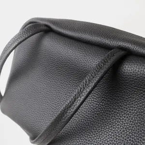 Gros plan détaillé d'un sac à épaule pour femme en cuir véritable avec surface grainée texturée.