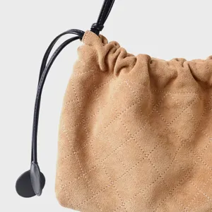 Vue détaillée d'un sac seau matelassé en suède chameau pour femme avec motif losanges.